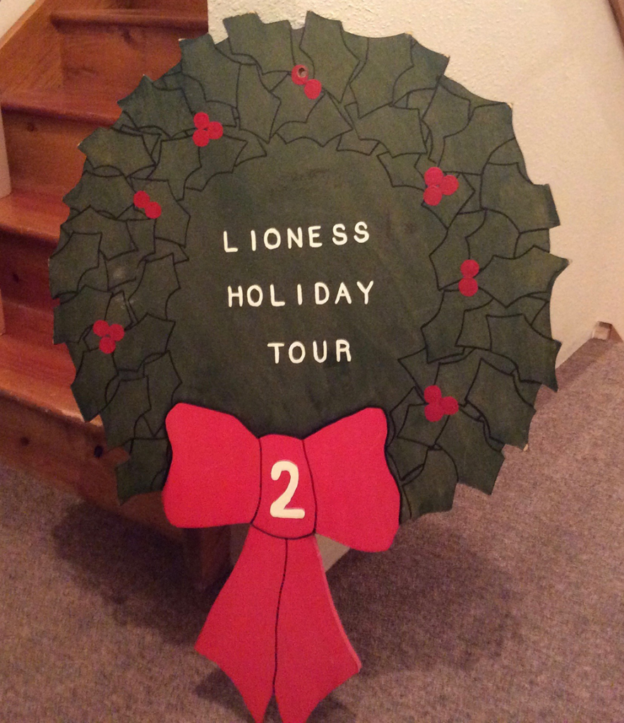Painted holiday wreath that says "lioness holiday tour"
