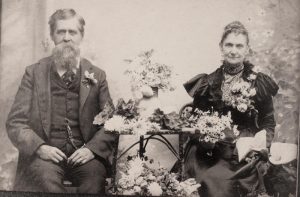James Clinton Brown and his wife Lucretia/Merticia Tipple Brown. This photo taken Jan 19, 1900 with flowers from their garden.