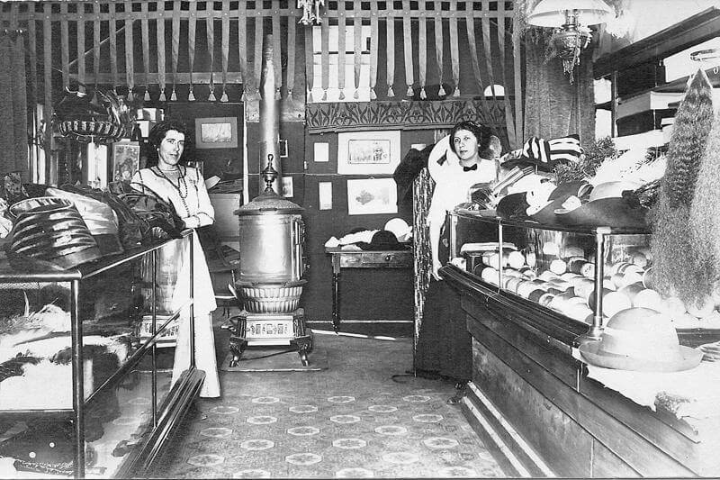Two women standing in old fashioned store.