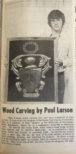 Paul Larson holds a framed wood carving he completed.