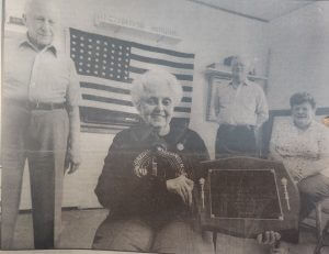 Woman holding a dedication of the museum plaque
