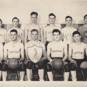Boy's basketball team seated on a bench.